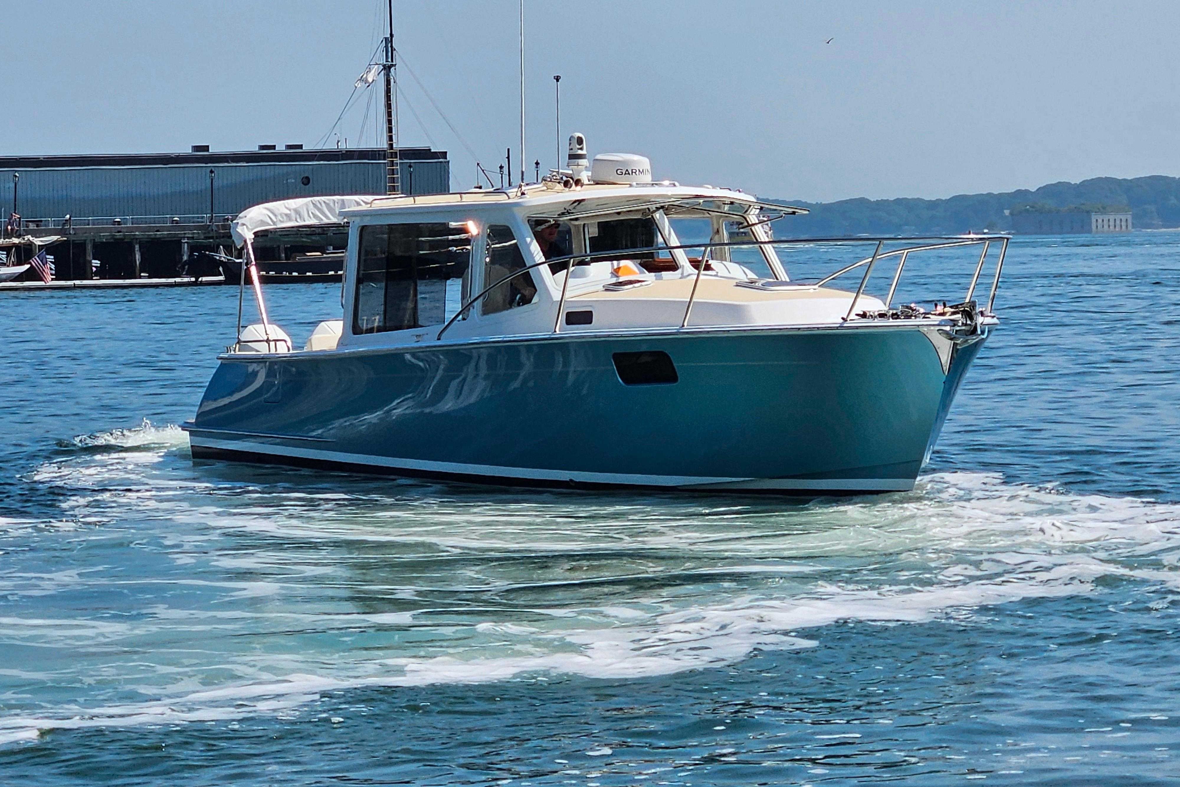 2023 MJM 35 boat cruising on calm waters near a dock.