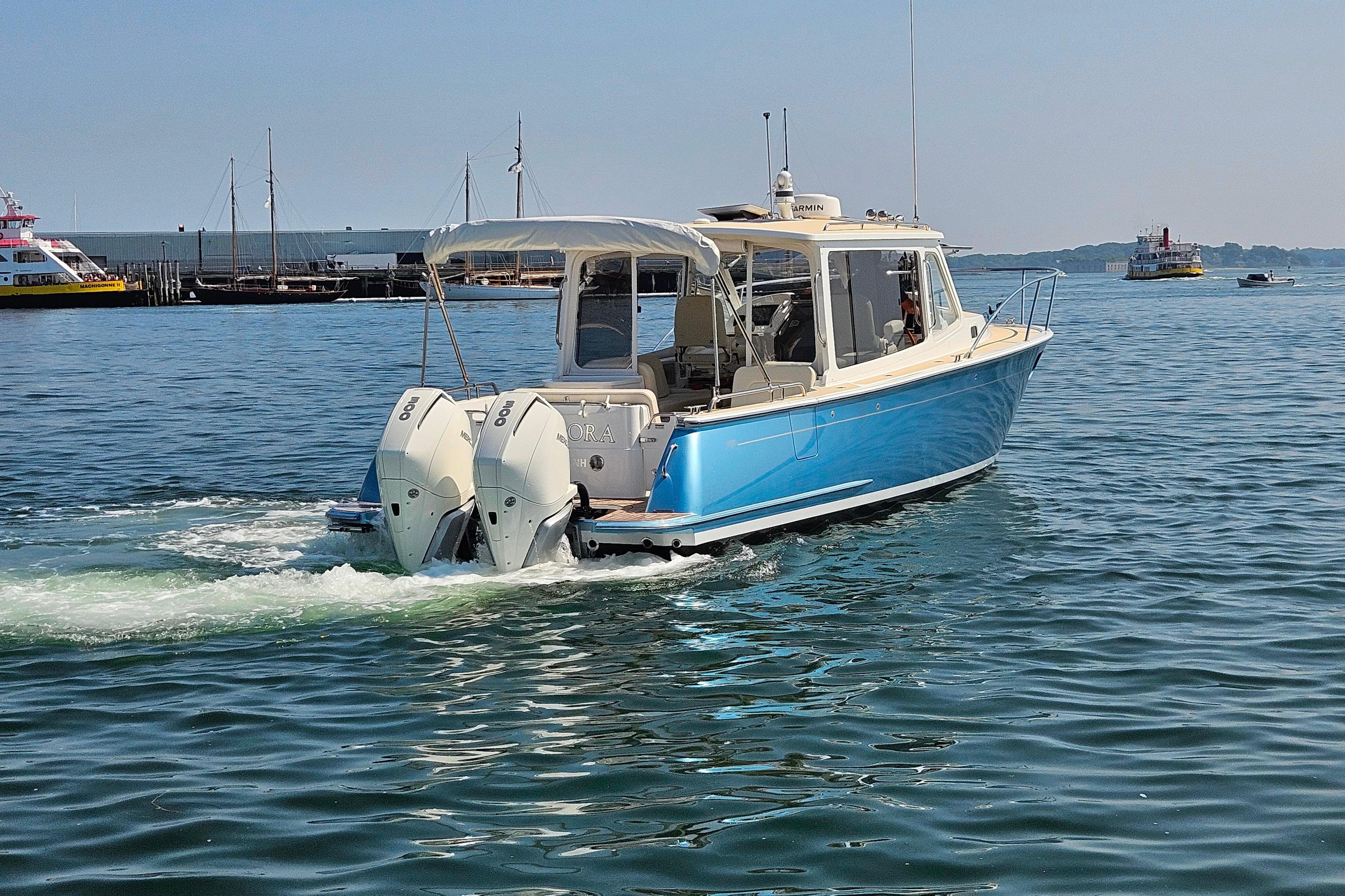 2023 MJM 35 boat cruising on calm waters with twin outboard engines.