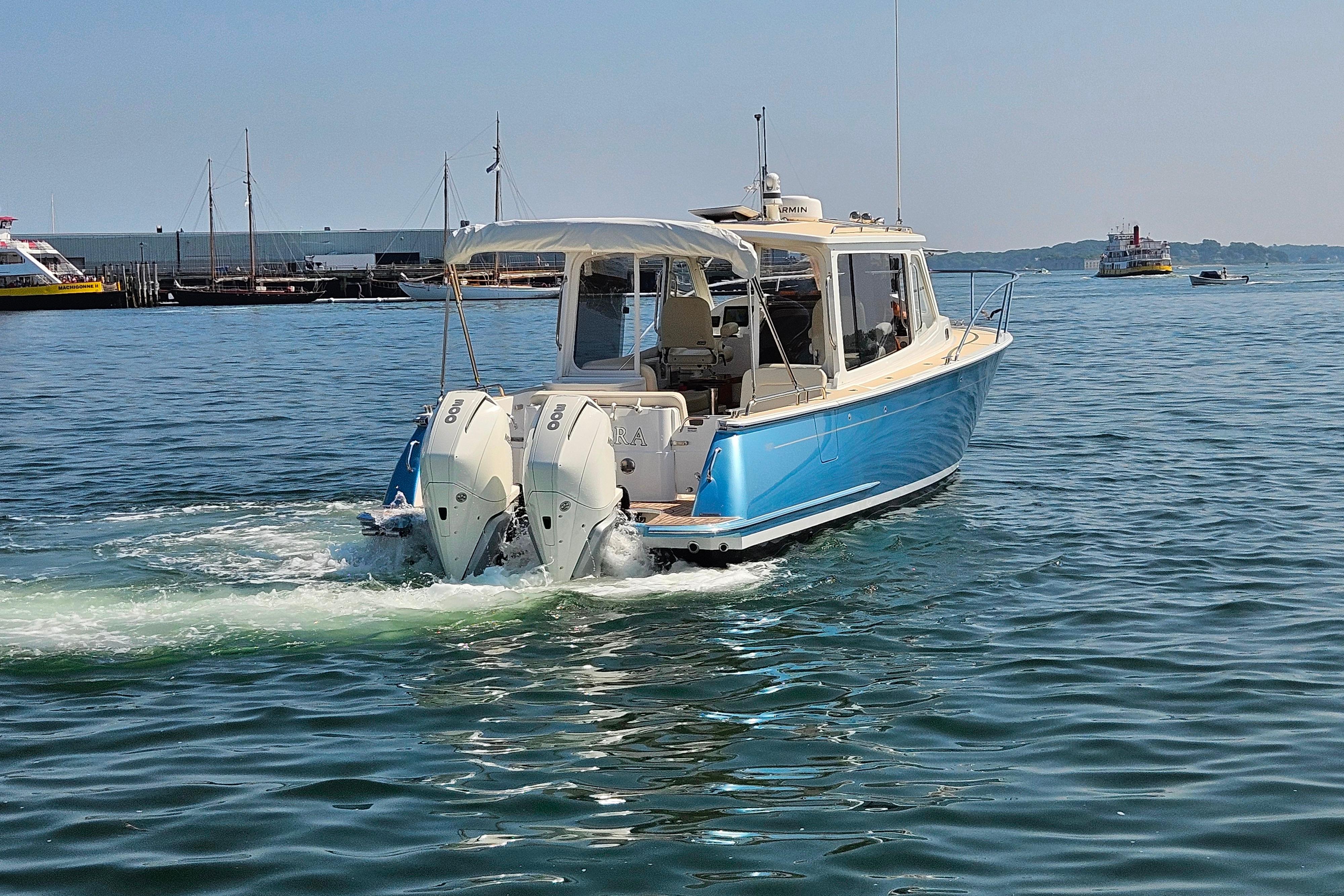 2023 MJM 35 boat cruising on calm waters with twin outboard engines.