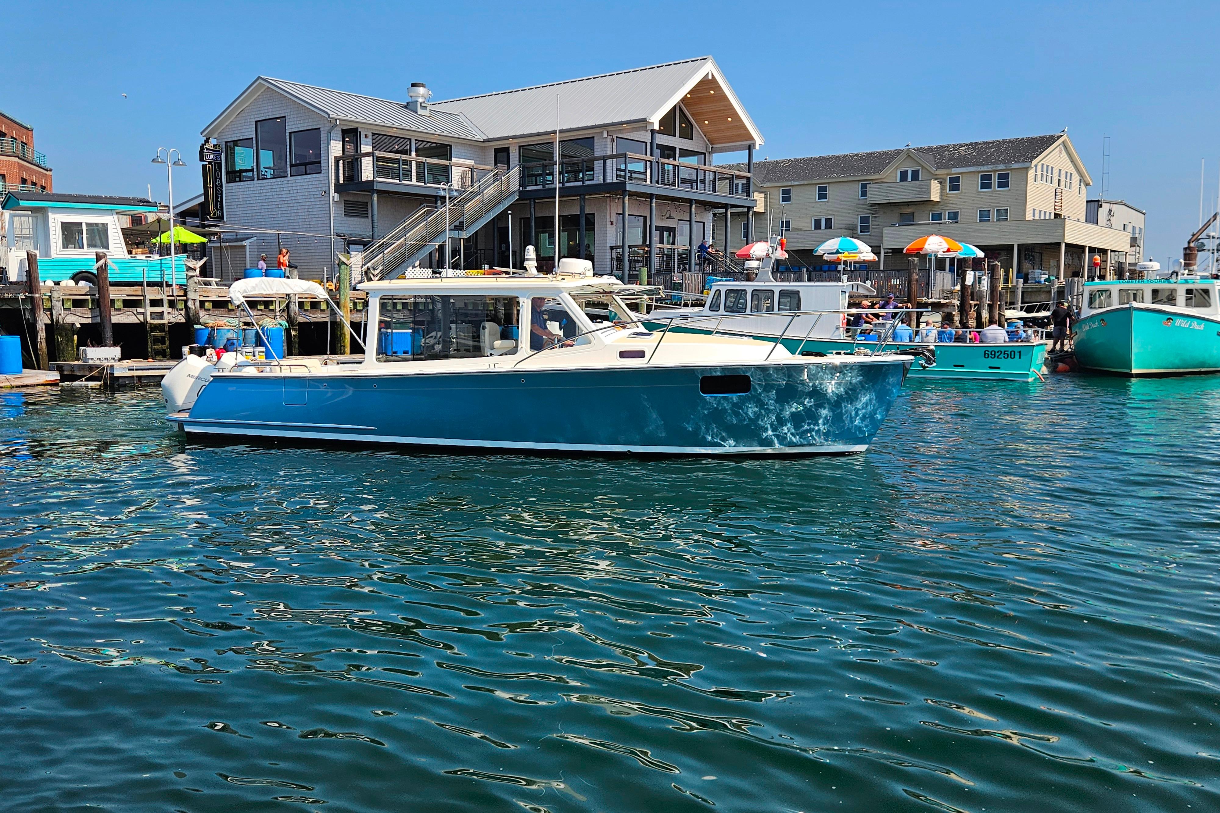 2023 MJM 35 boat docked at a vibrant marina with colorful umbrellas.