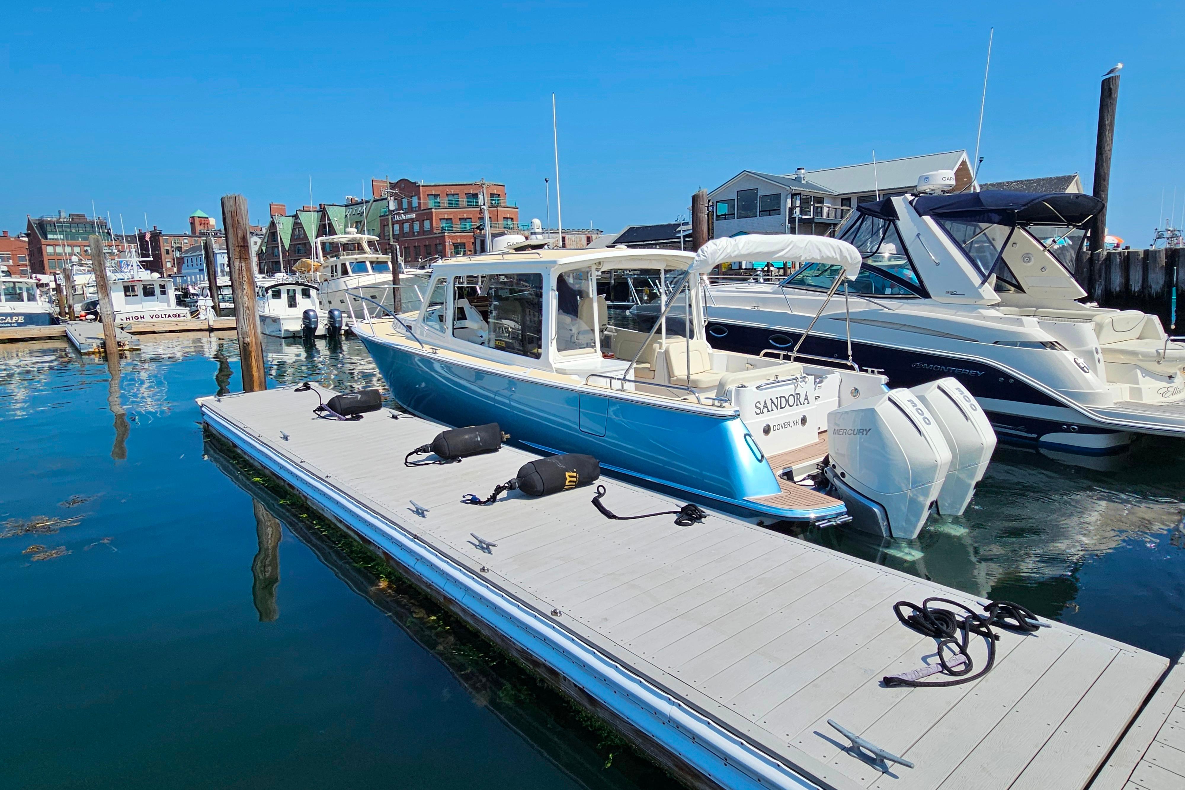 2023 MJM 35 boat docked in a marina, surrounded by other vessels.