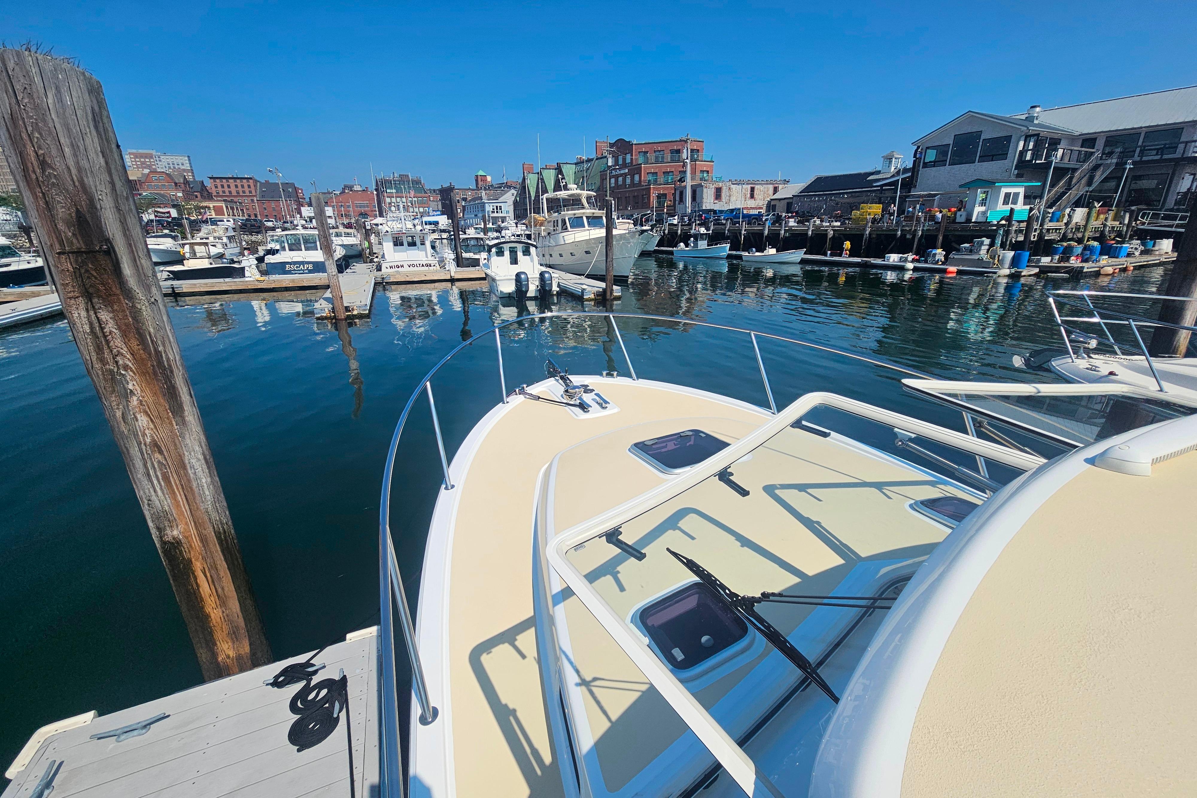 2023 MJM 35 boat docked in a bustling marina with clear blue skies.