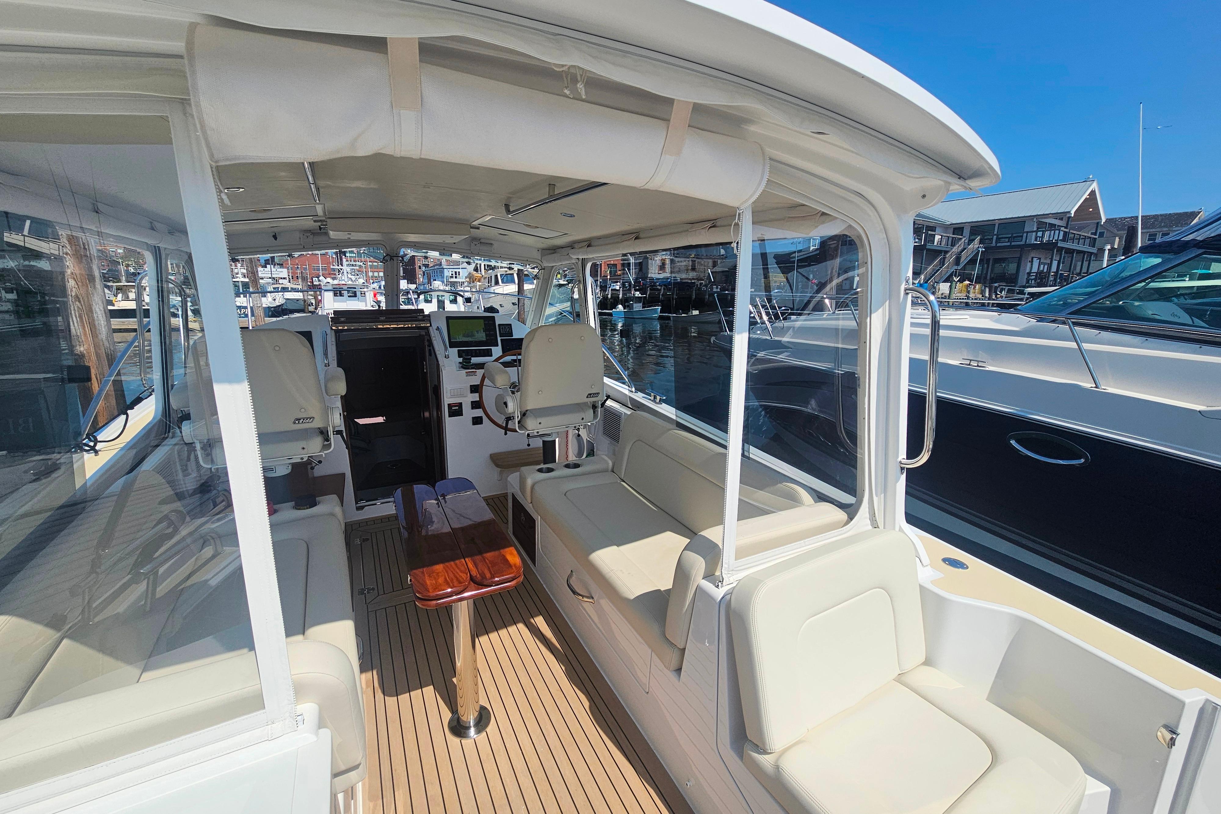 2023 MJM 35 boat interior with seating, helm, and marina view.