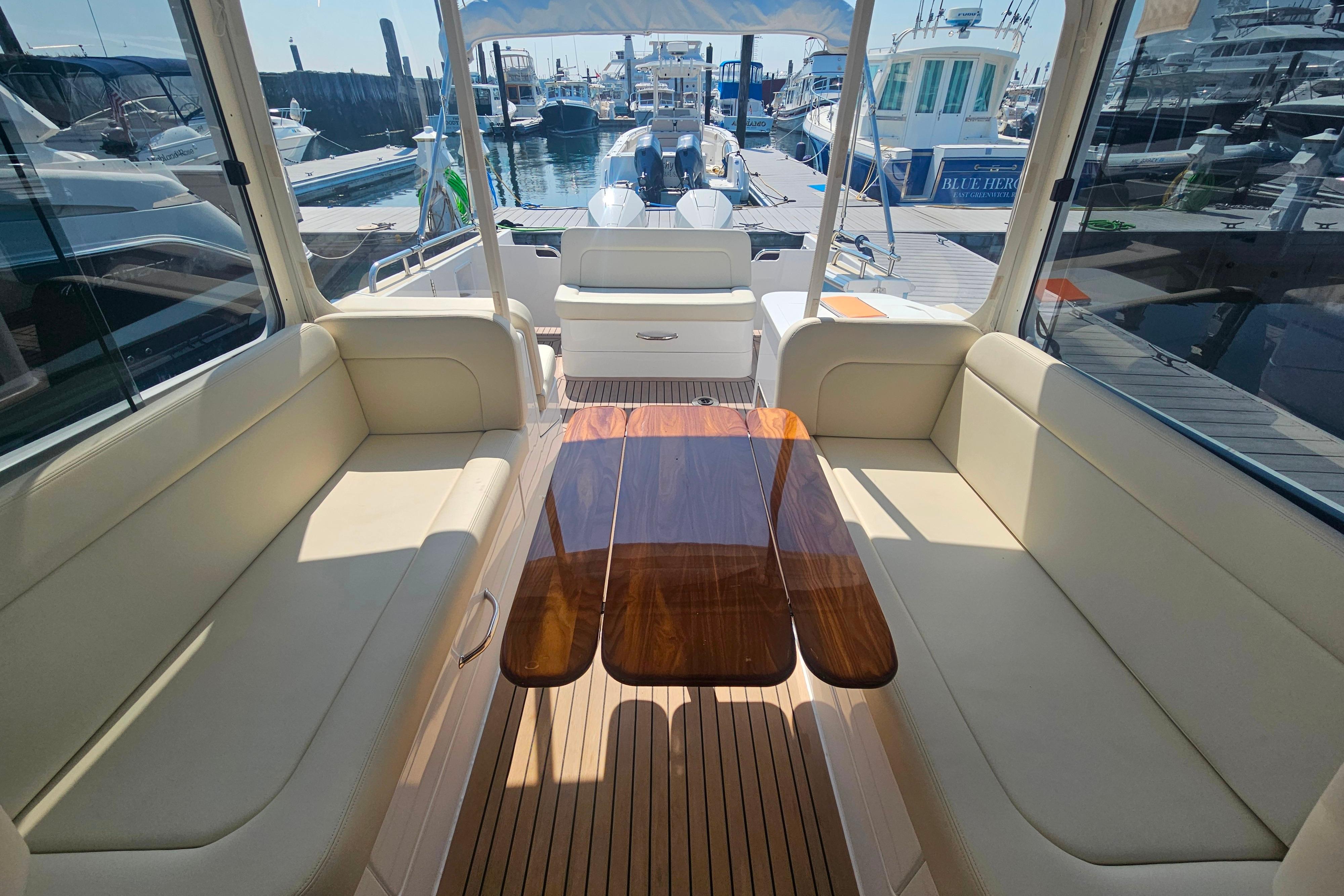 Luxurious 2023 MJM 35 yacht interior with elegant seating and polished wooden table.