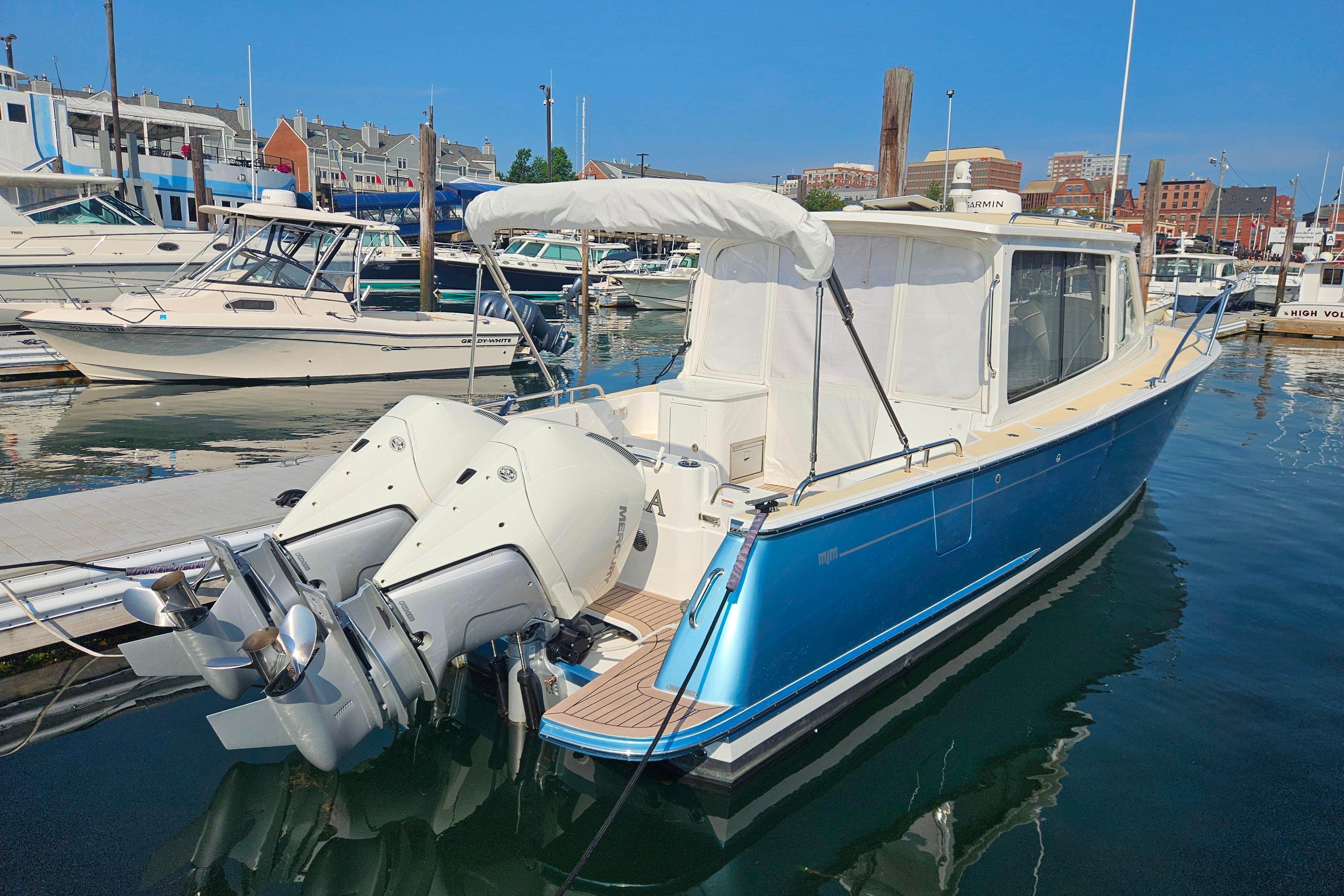 2023 MJM 35 boat docked in marina with twin outboard engines.
