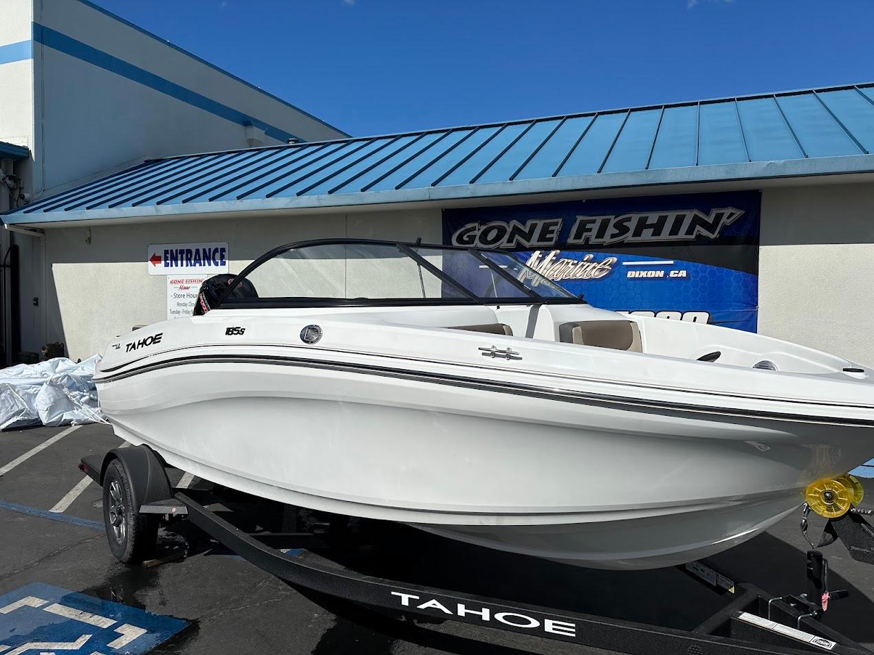 2025 Tahoe 185 S boat on trailer, parked outside a building with blue roof.