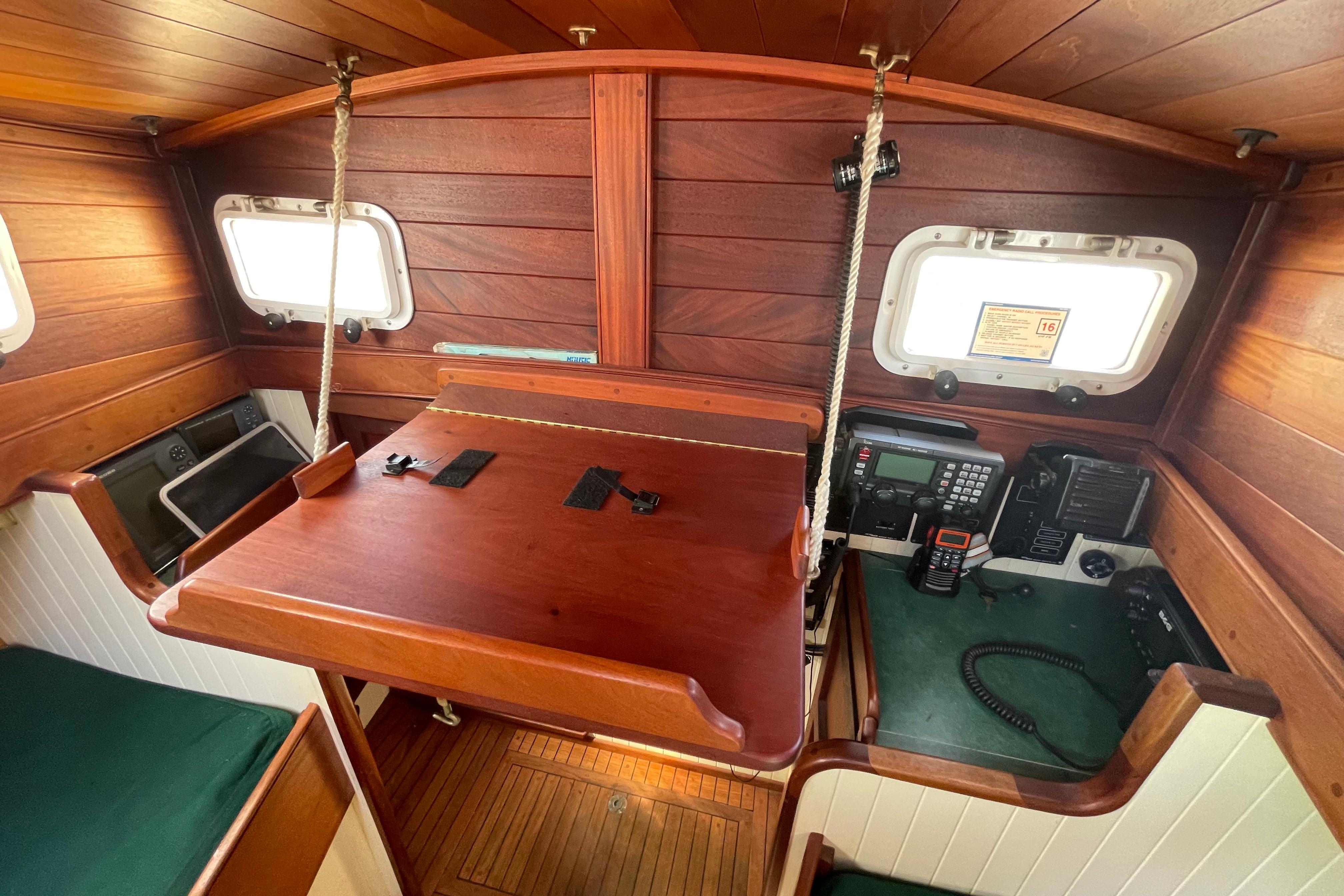 Wooden interior of 2008 Pinky Custom boat with navigation equipment and foldable table.