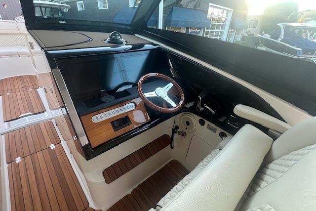 2024 Chris-Craft Calypso 35 helm with wooden steering wheel and modern dashboard.