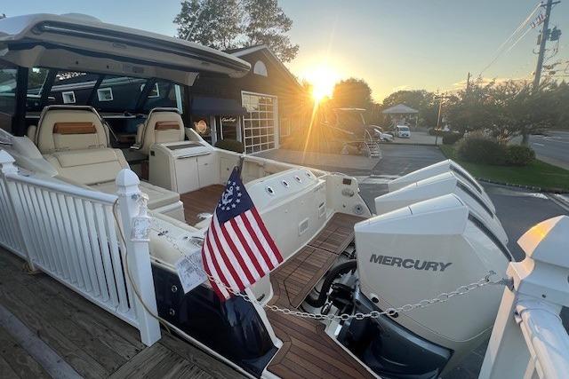 2024 Chris-Craft Calypso 35 boat with Mercury engines at sunset, featuring American flag.