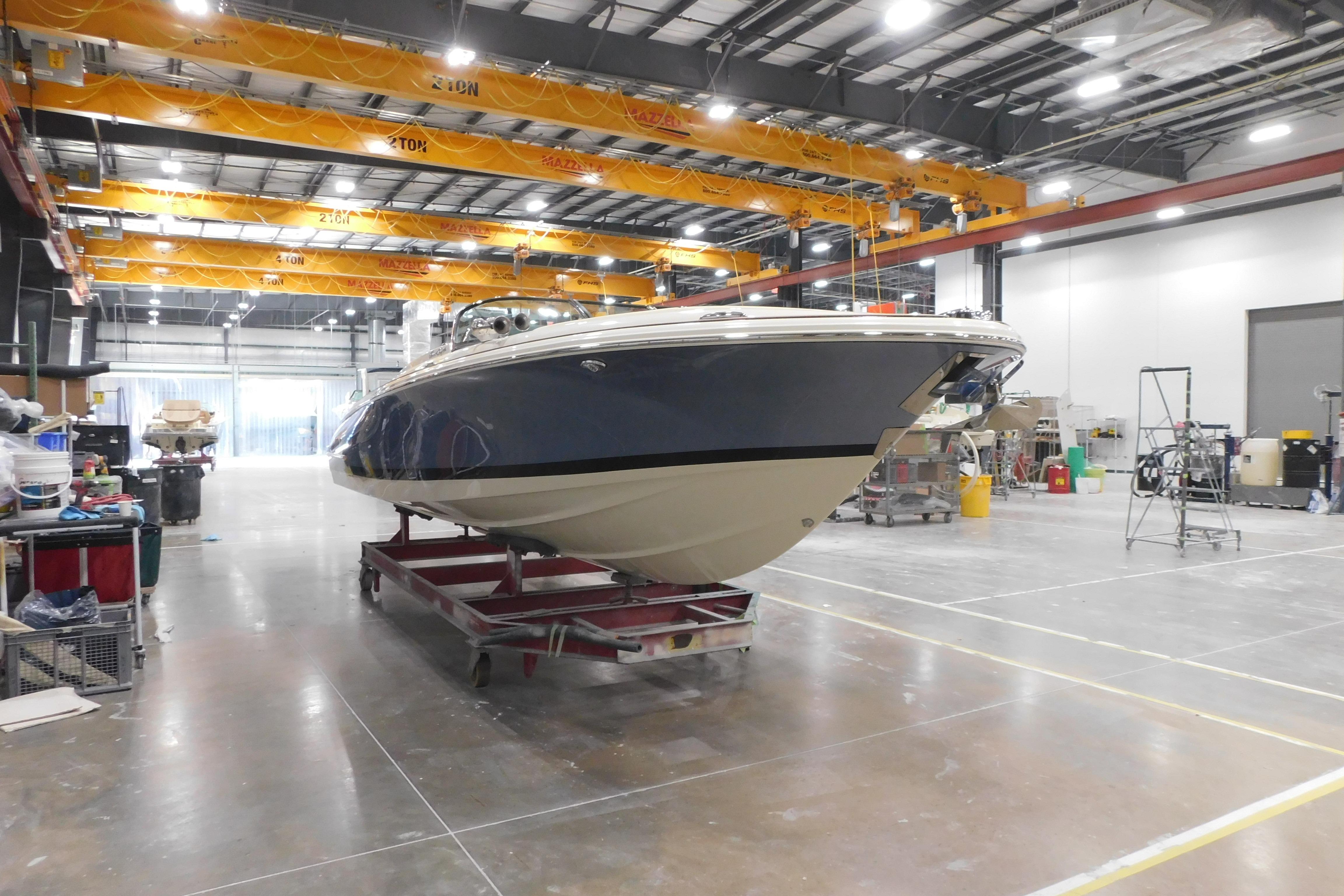 2026 Chris-Craft Launch 27 boat in a spacious indoor workshop setting.