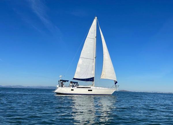 Sailboat Gib'Sea 126, 1985 model, sailing on calm blue waters under clear skies.