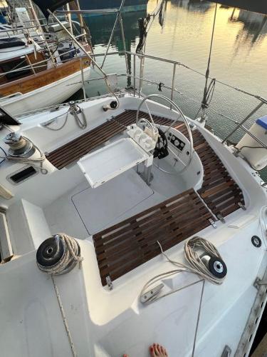 1985 Gib'Sea 126 sailboat cockpit with wooden seating and steering wheel, docked at sunset.