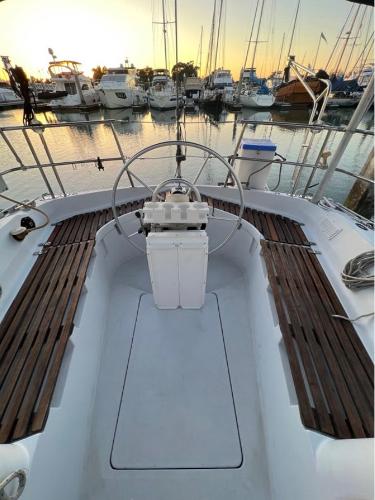 1985 Gib'Sea 126 sailboat cockpit with wooden benches, docked at sunset.