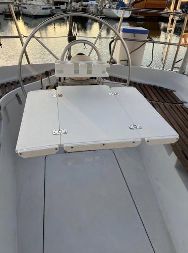 Cockpit of 1985 Gib'Sea 126 sailboat with steering wheel and foldable table.
