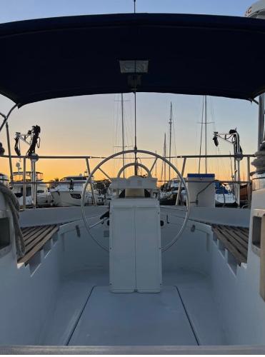 Cockpit view of 1985 Gib'Sea 126 sailboat at sunset in marina.