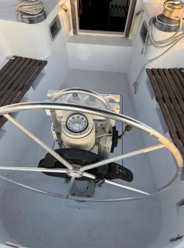 Cockpit of 1985 Gib'Sea 126 sailboat with steering wheel and navigation equipment.