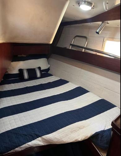 Cozy cabin interior of 1985 Gib'Sea 126 sailboat with striped bedding.