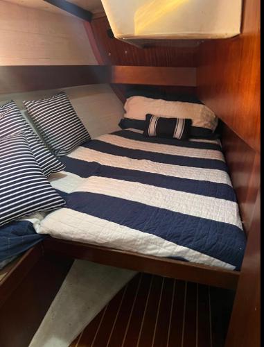 Cozy cabin interior of 1985 Gib'Sea 126 sailboat with striped bedding.