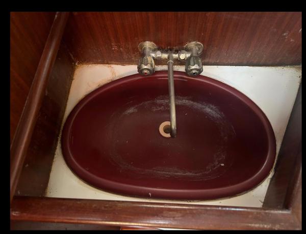 Maroon sink with vintage faucet on 1985 Gib'Sea 126 yacht.