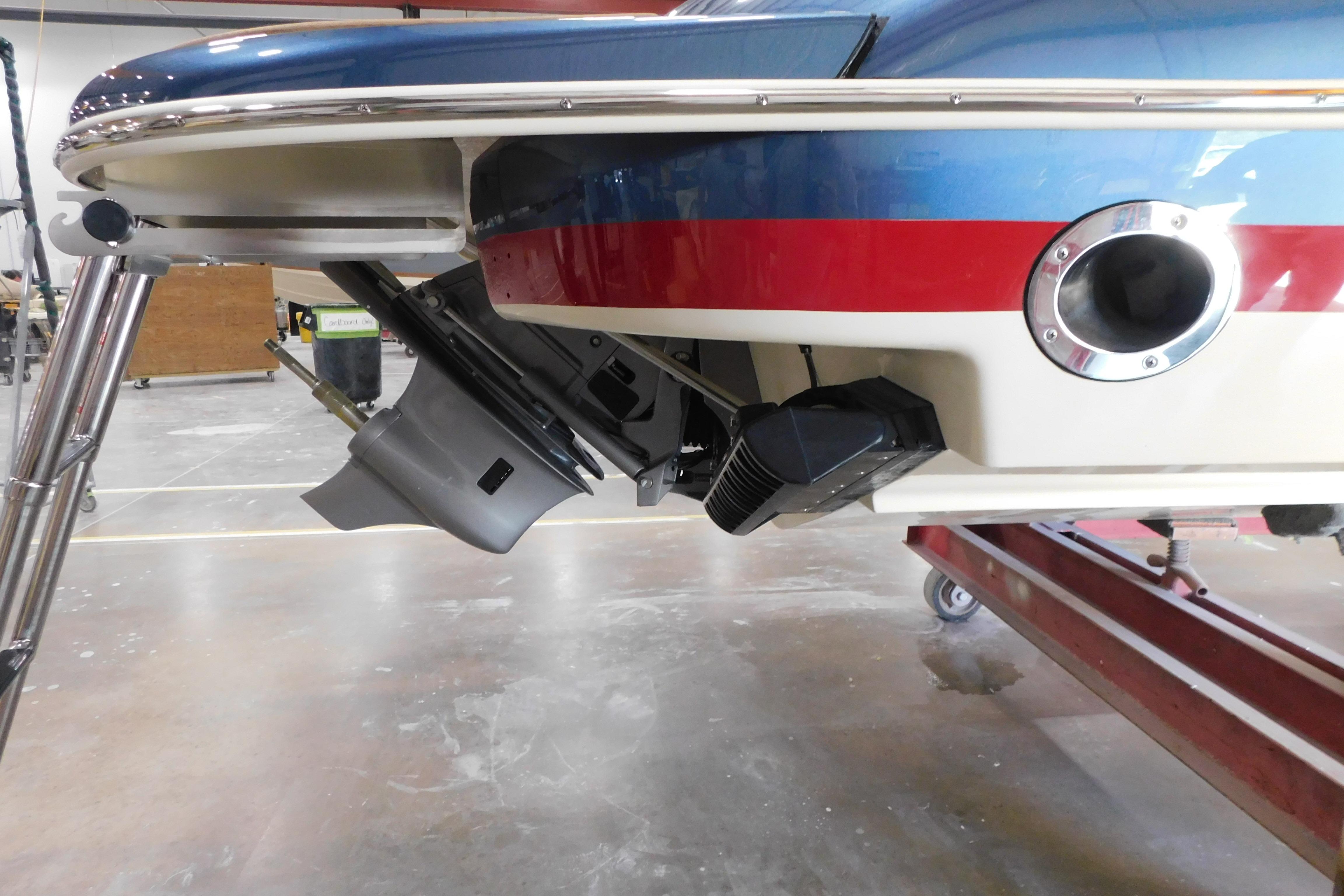 2025 Chris-Craft Launch 27 boat stern view in a workshop setting.