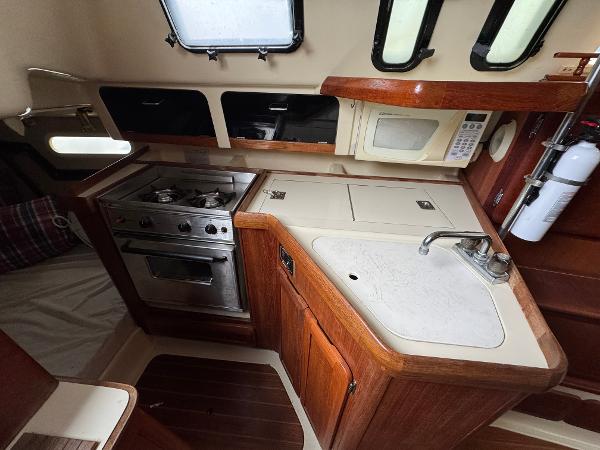 1994 Hunter 29.5 yacht kitchen with stove, sink, and microwave.