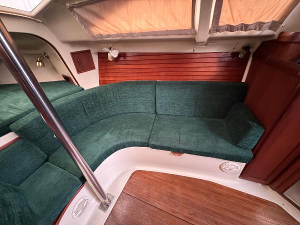 Interior of a 1994 Hunter 29.5 sailboat with green seating and wood accents.