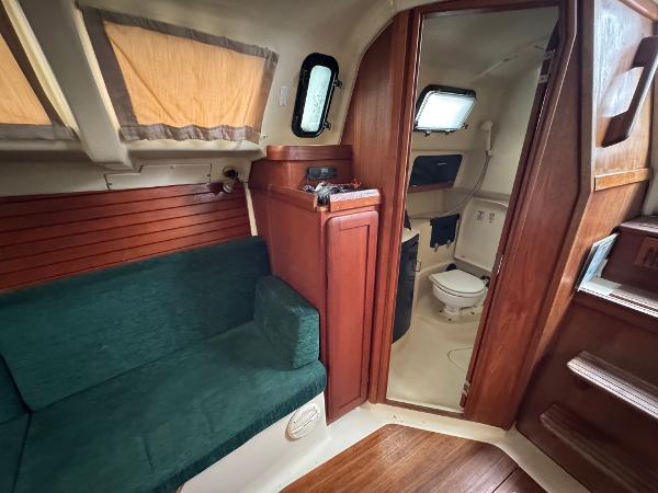 Interior of 1994 Hunter 29.5 sailboat with green seating and wooden cabinetry.