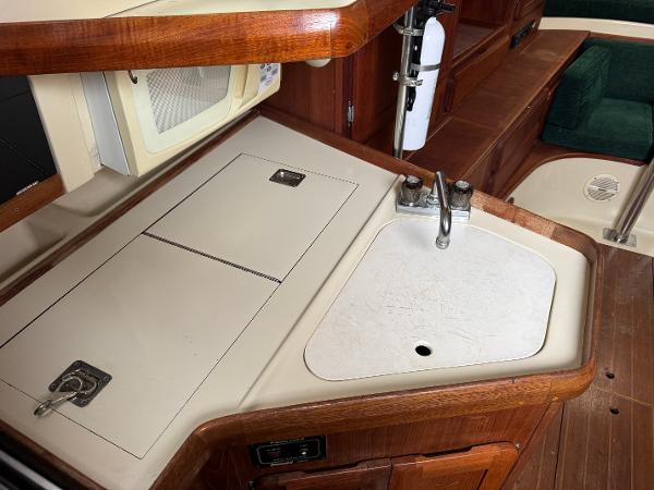 1994 Hunter 29.5 yacht interior kitchen with sink and wooden cabinetry.