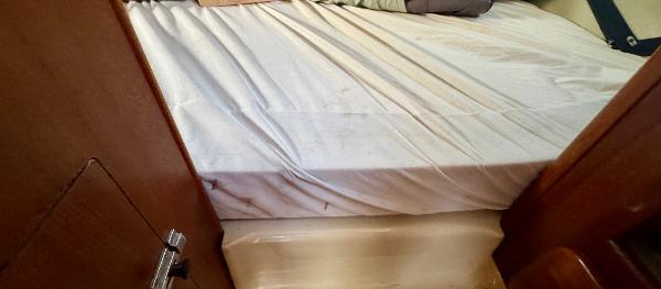 Interior cabin of 1994 Hunter 29.5 sailboat with bed and wooden paneling.