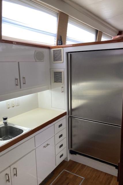 Bertram-58 Motor Yacht 1977-K Bear FL-US-1977 Bertram 58 Motor Yacht kitchen with stainless steel fridge and white cabinetry.-9617651 | Thumbnail