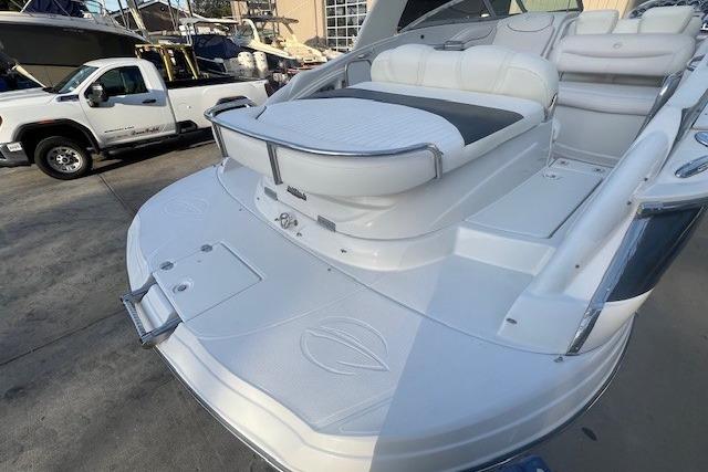 2007 Crownline 320 LS boat with spacious seating and swim platform, parked near a truck.