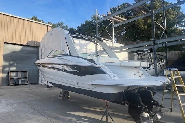 2007 Crownline 320 LS boat on dry dock, outdoor storage area, clear sky.