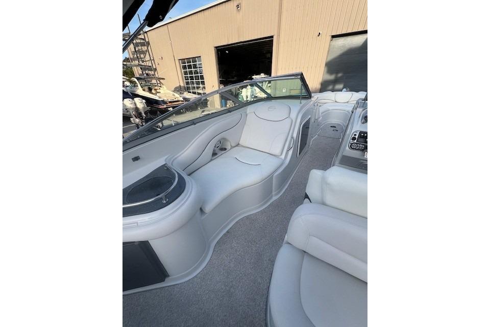 2007 Crownline 320 LS boat interior with white seating and dashboard, docked near a building.