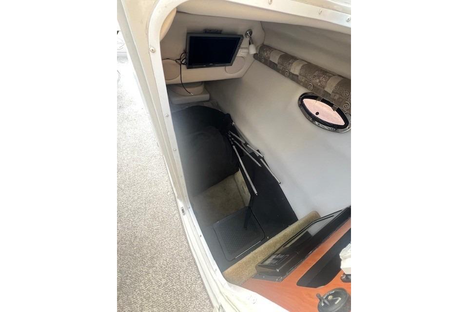 2007 Crownline 320 LS cabin interior with porthole and electronic equipment.