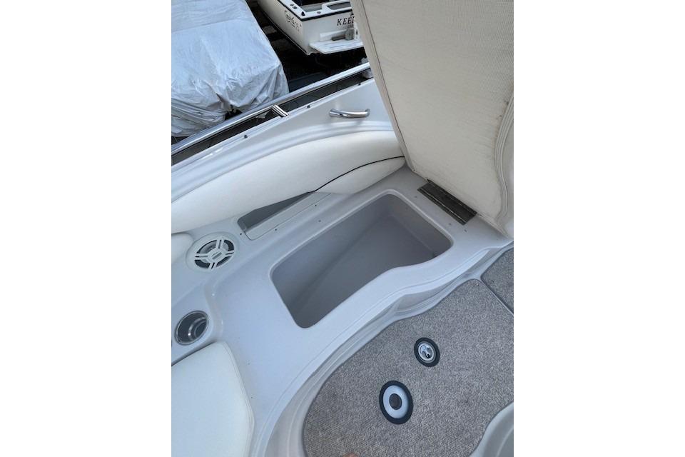 2007 Crownline 320 LS boat interior storage compartment with speaker and carpeted flooring.