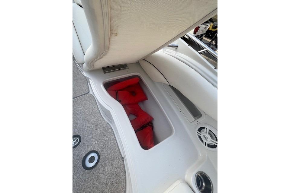 Storage compartment with red life jackets on a 2007 Crownline 320 LS boat.