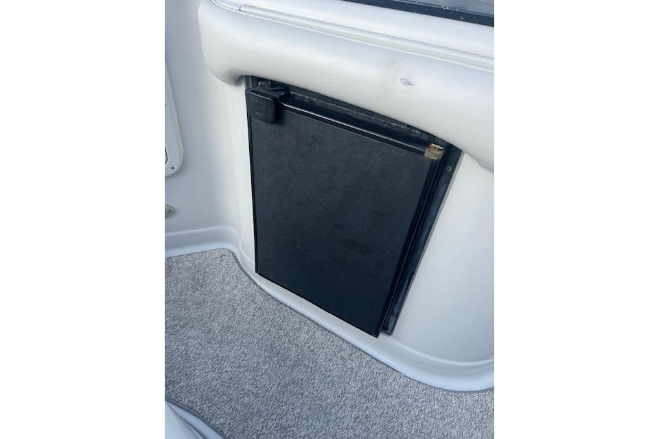 2007 Crownline 320 LS boat interior with compact black refrigerator.