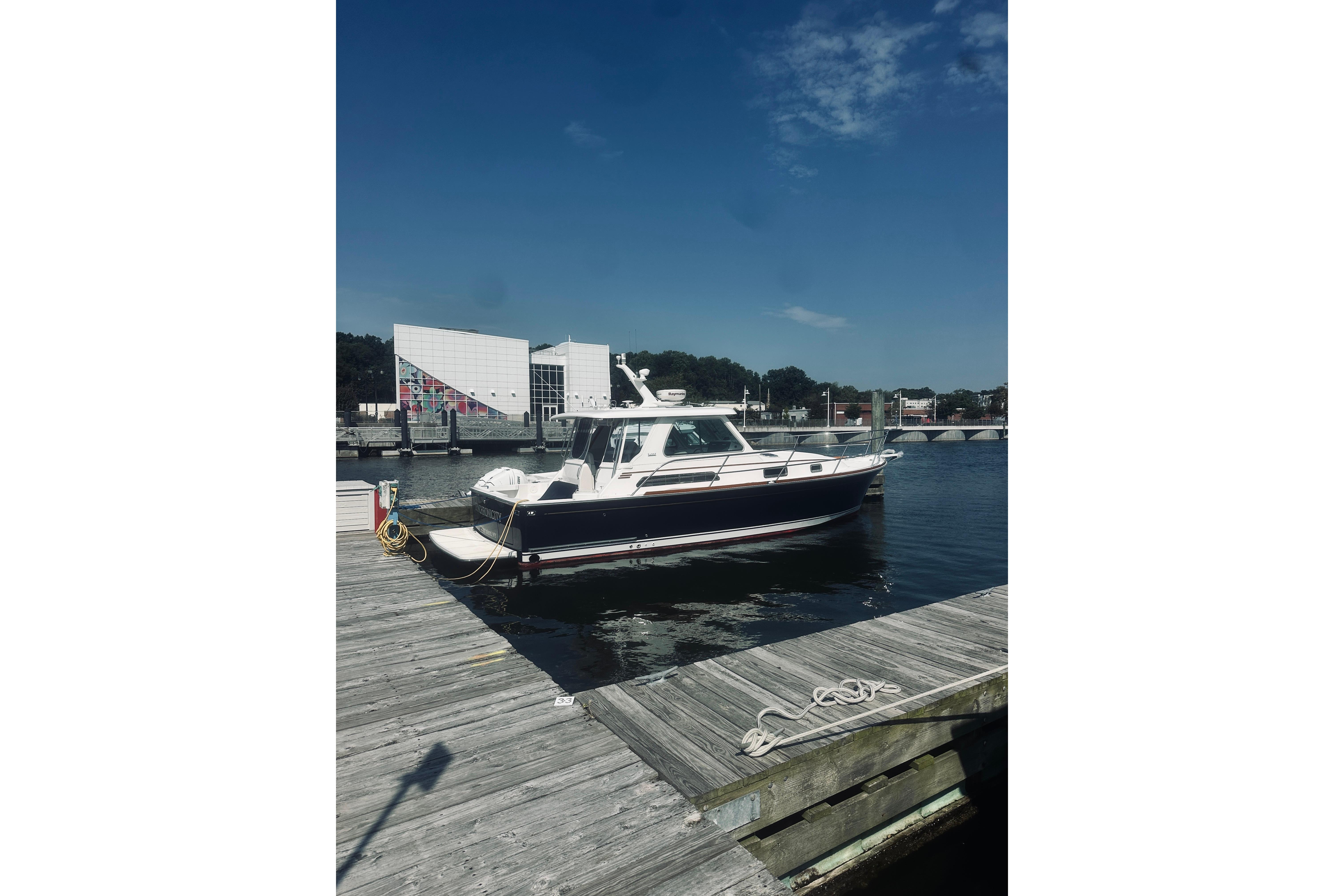 2007 Sabre 34 Express yacht docked at a marina under a clear blue sky.