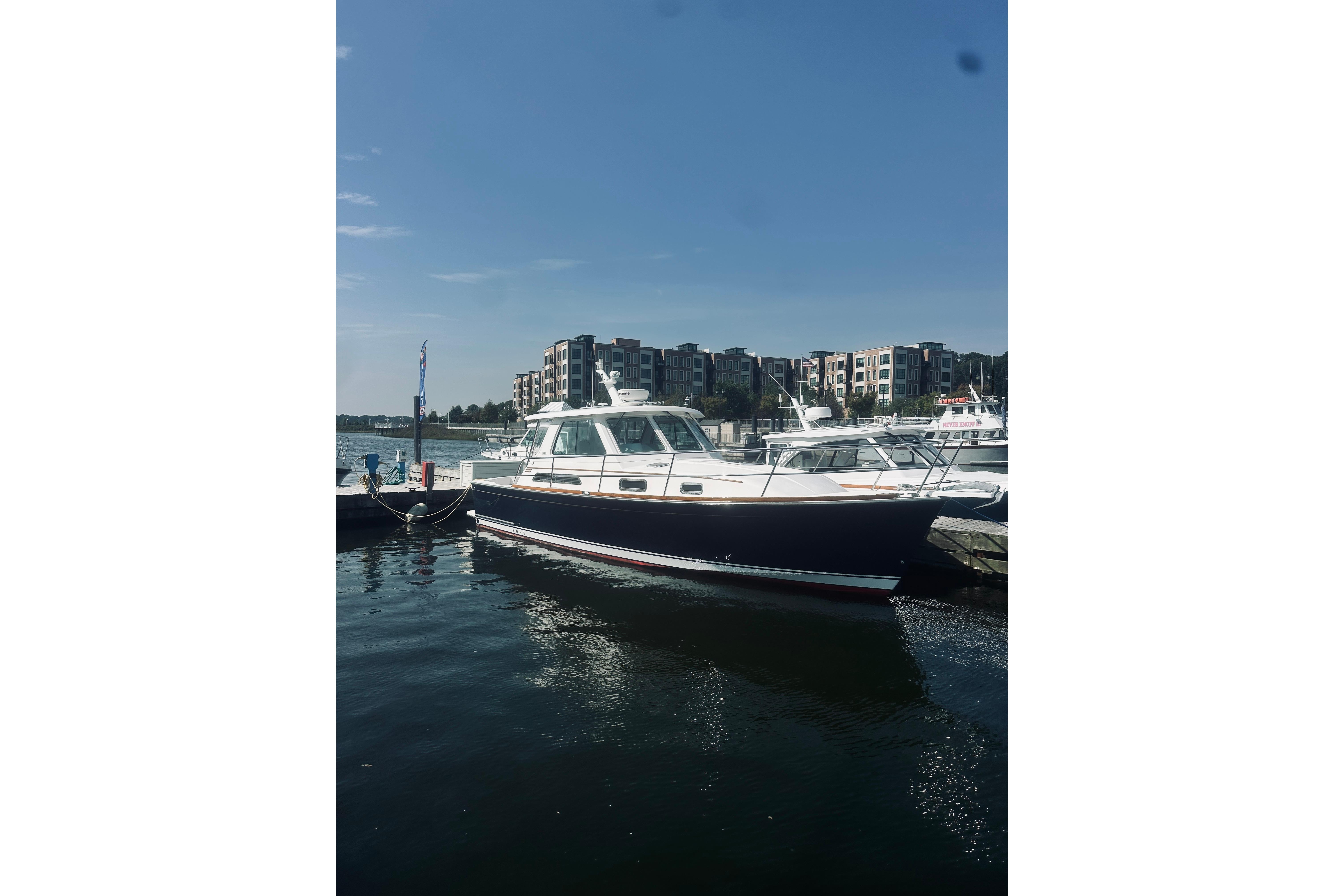 2007 Sabre 34 Express yacht docked in marina with modern buildings in background.