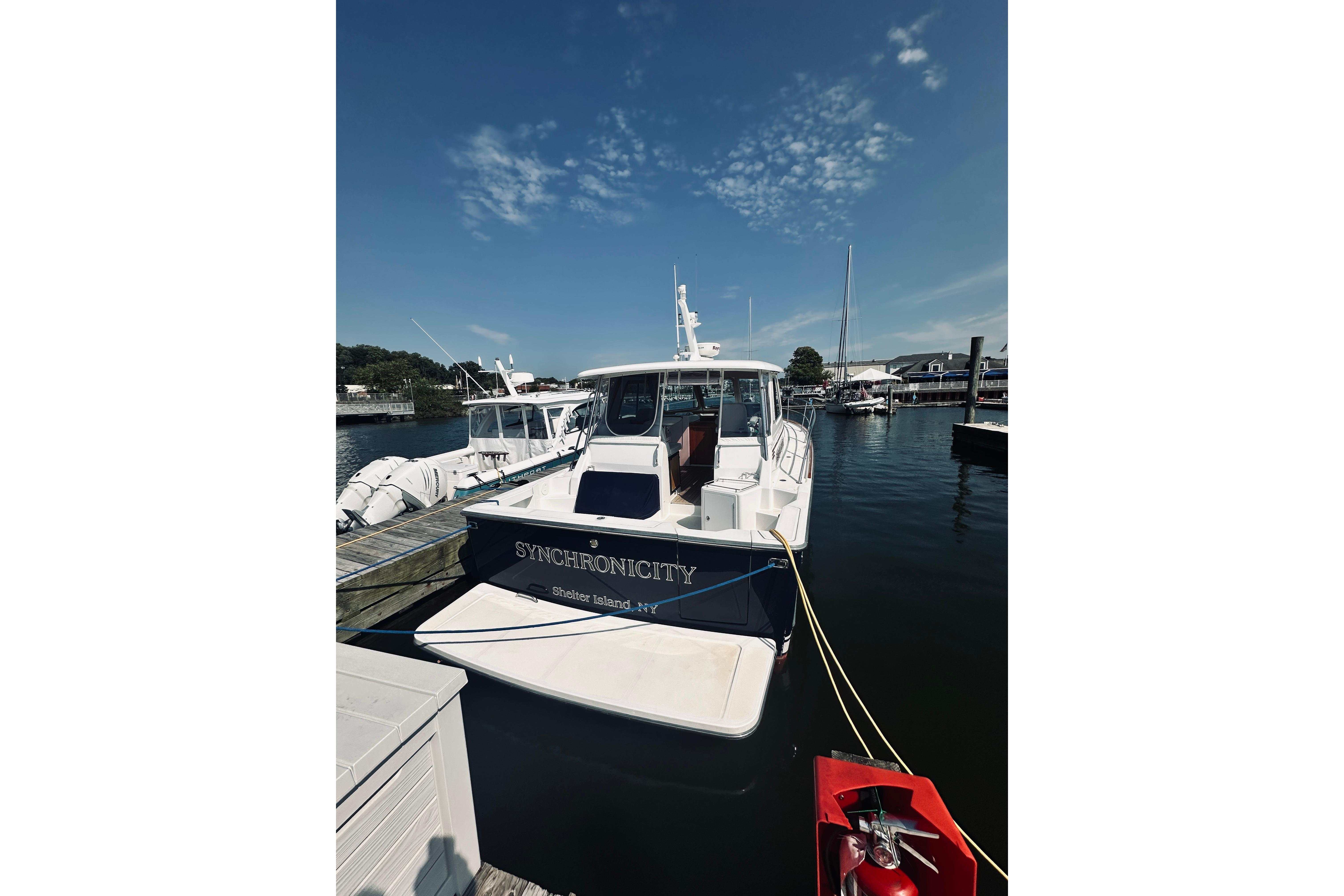 2007 Sabre 34 Express boat docked at marina under clear blue sky.