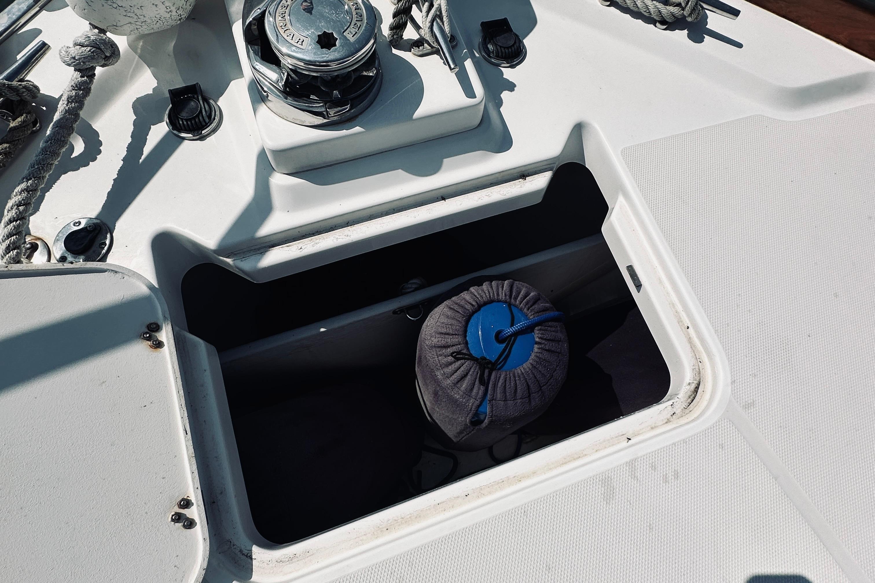 2007 Sabreline 34 Express boat deck with open storage compartment and winch.
