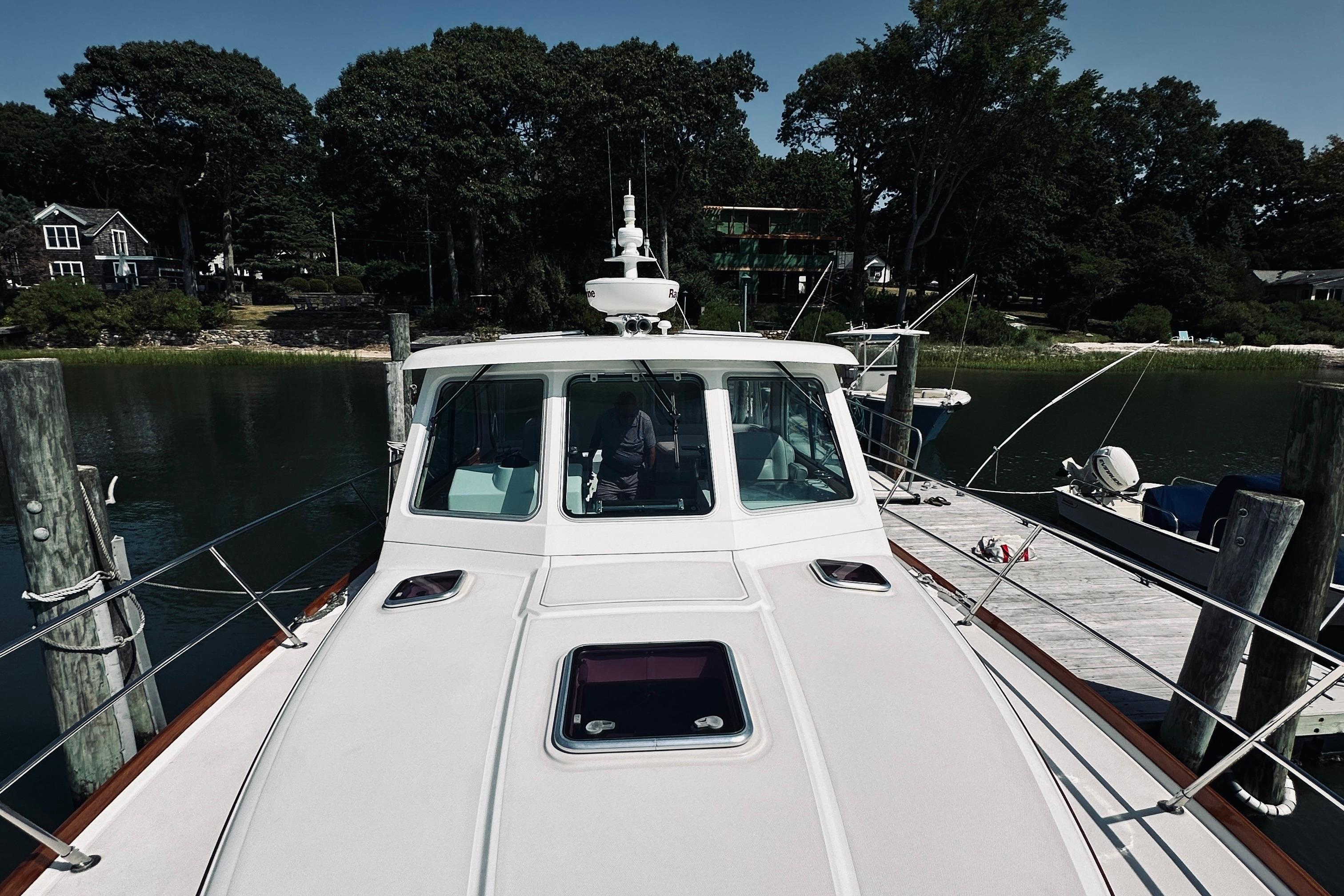 2007 Sabreline 34 Express yacht docked at a serene marina with lush greenery.