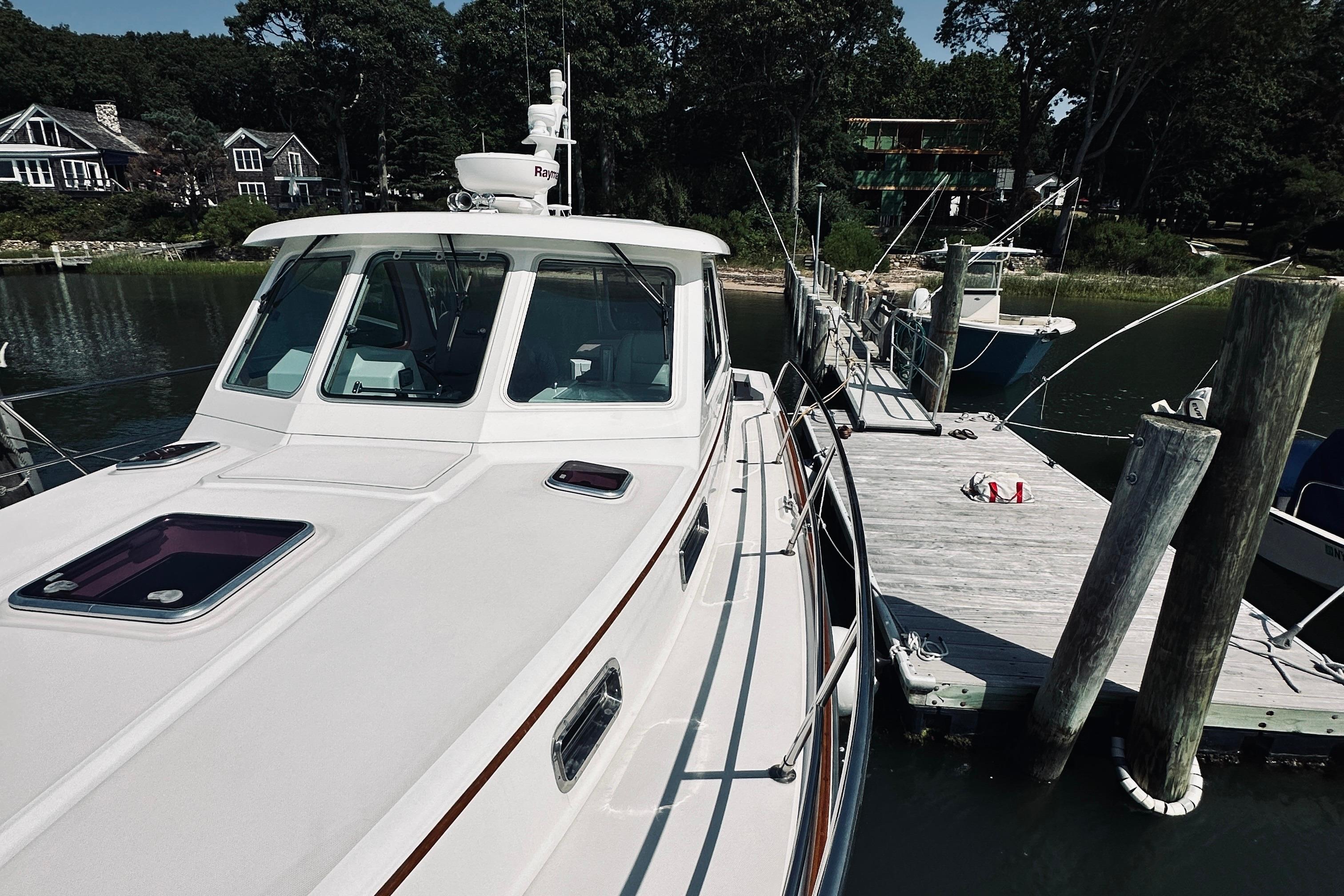 2007 Sabreline 34 Express yacht docked at a serene marina with lush surroundings.