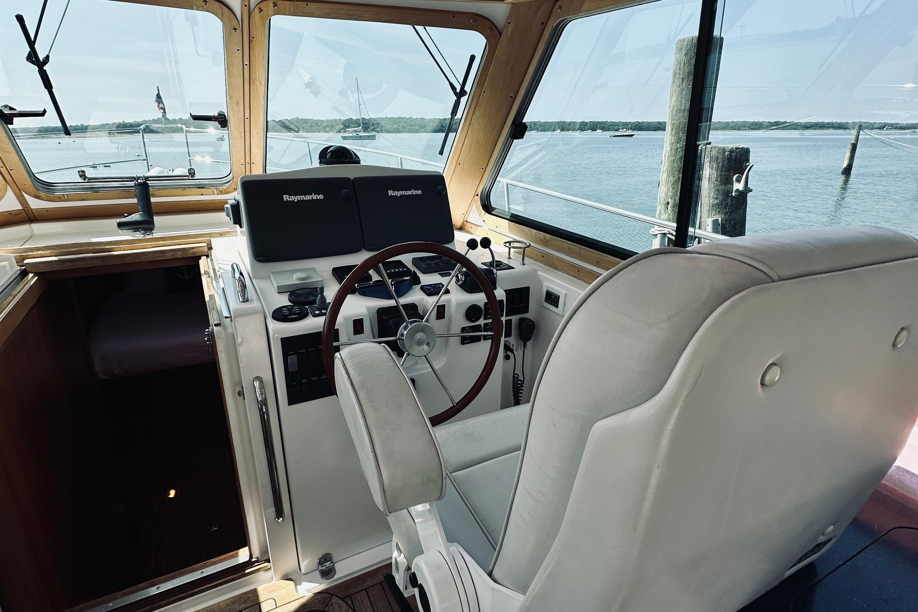 Interior helm of 2007 Sabreline 34 Express boat with steering wheel and navigation equipment.