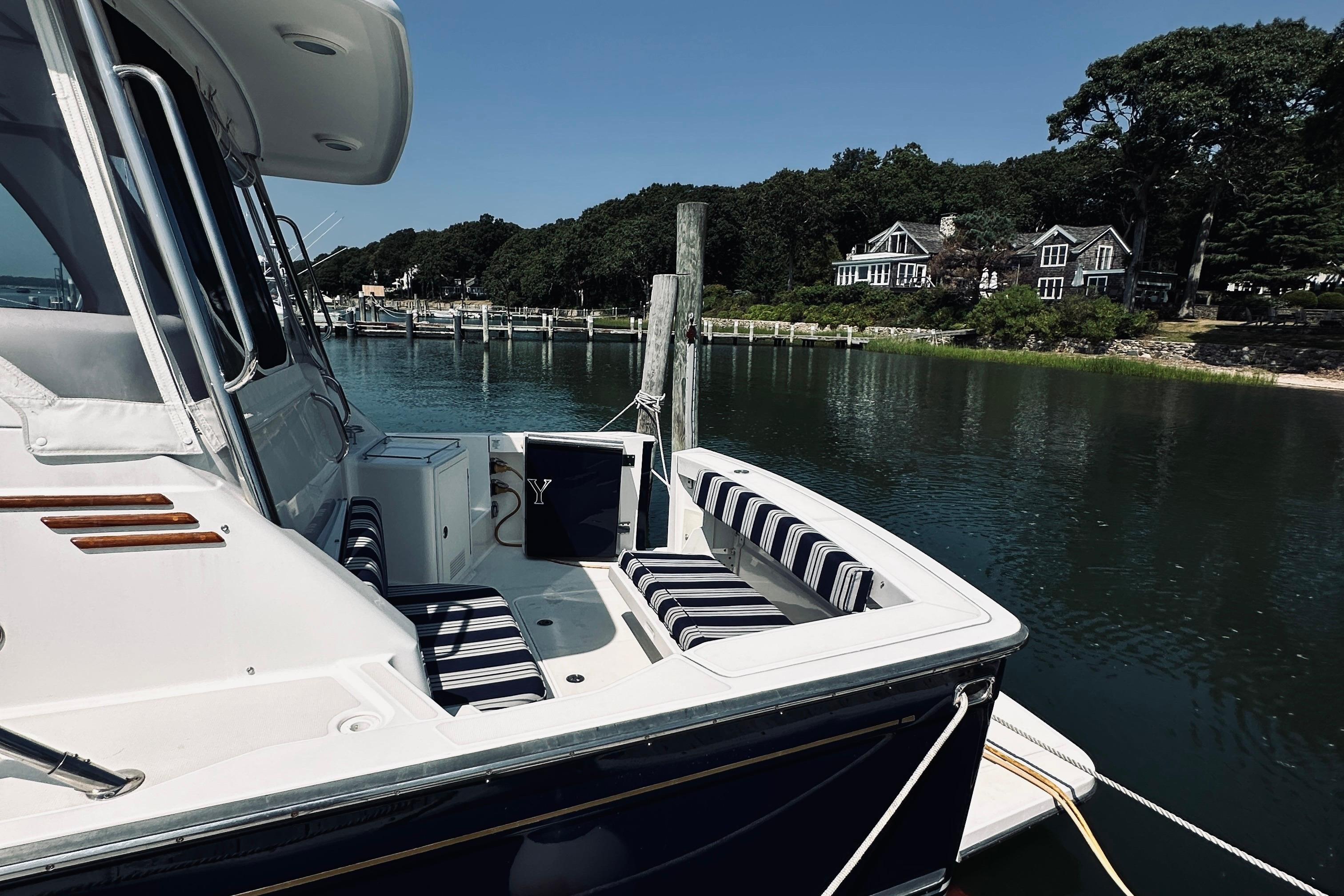 2007 Sabreline 34 Express yacht docked by scenic waterfront homes.