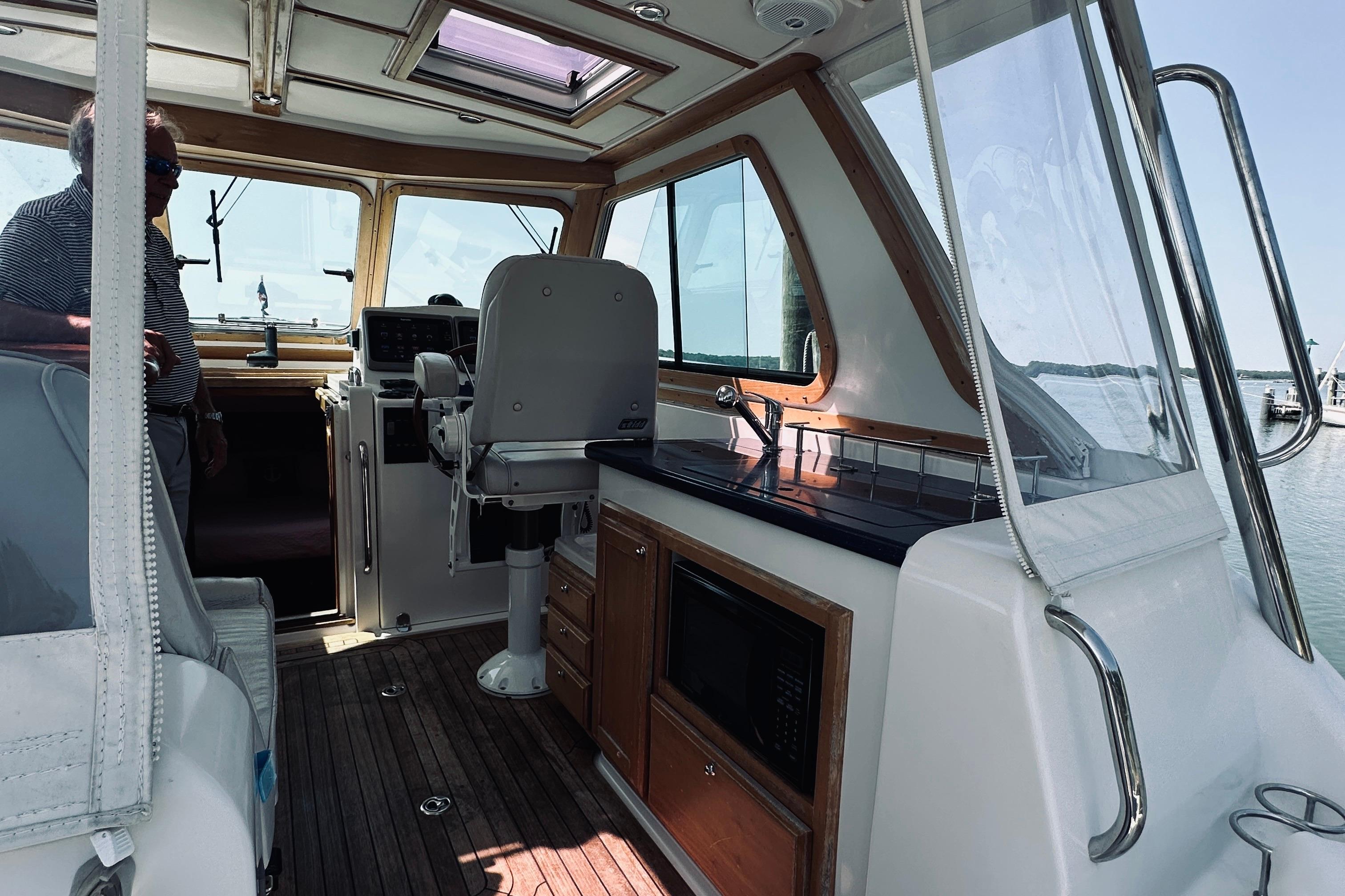 2007 Sabreline 34 Express boat interior with helm, seating, and kitchenette.