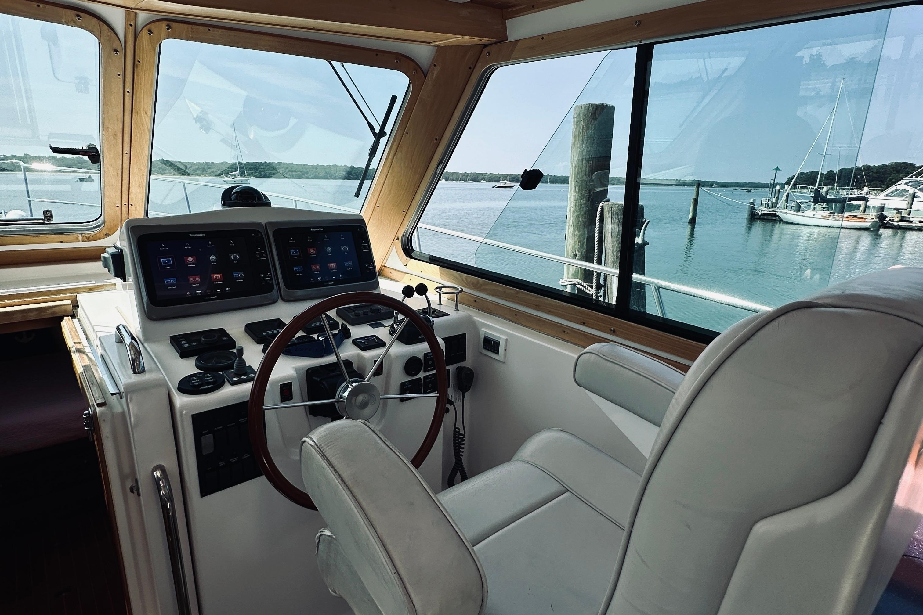 2007 Sabreline 34 Express helm with modern controls and scenic marina view.