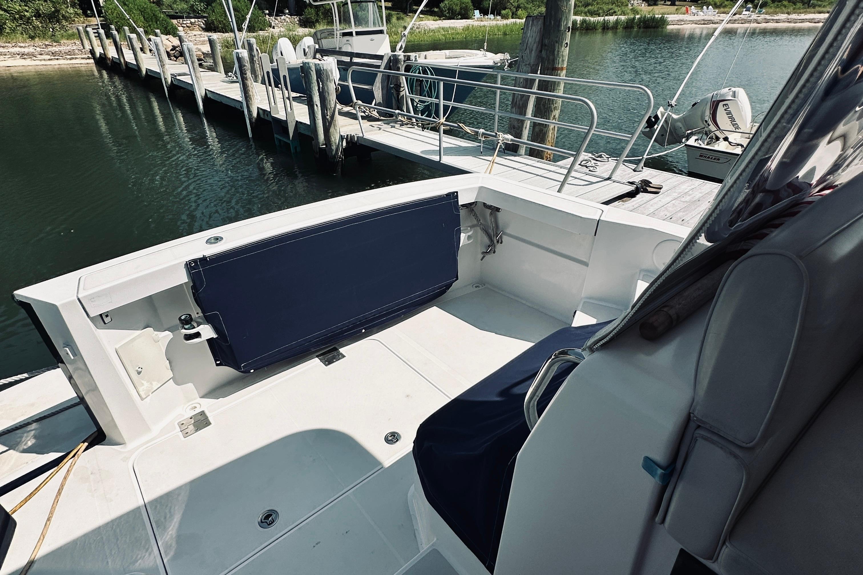 2007 Sabreline 34 Express boat interior at dock, featuring seating and railing.