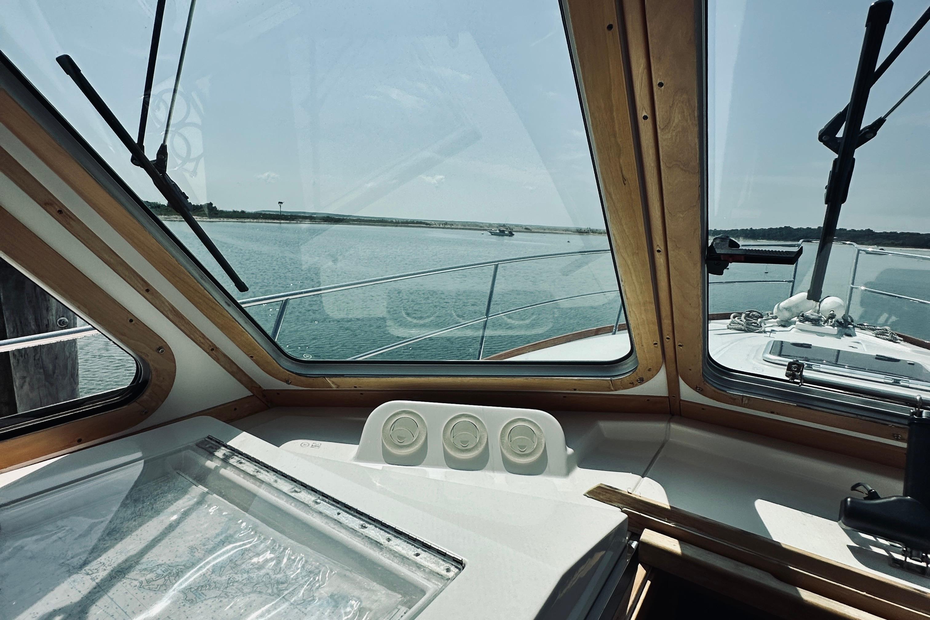 Interior view from 2007 Sabreline 34 Express yacht, overlooking calm waters through large windows.