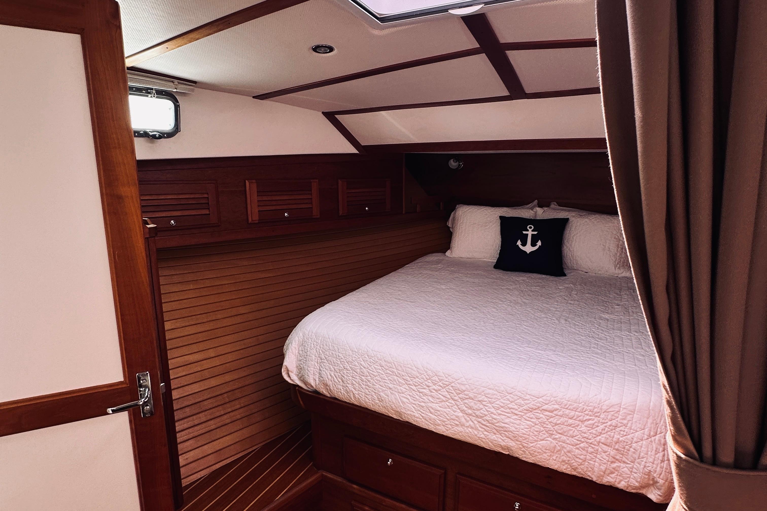 Luxurious cabin interior of 2007 Sabreline 34 Express with cozy bedding and nautical decor.